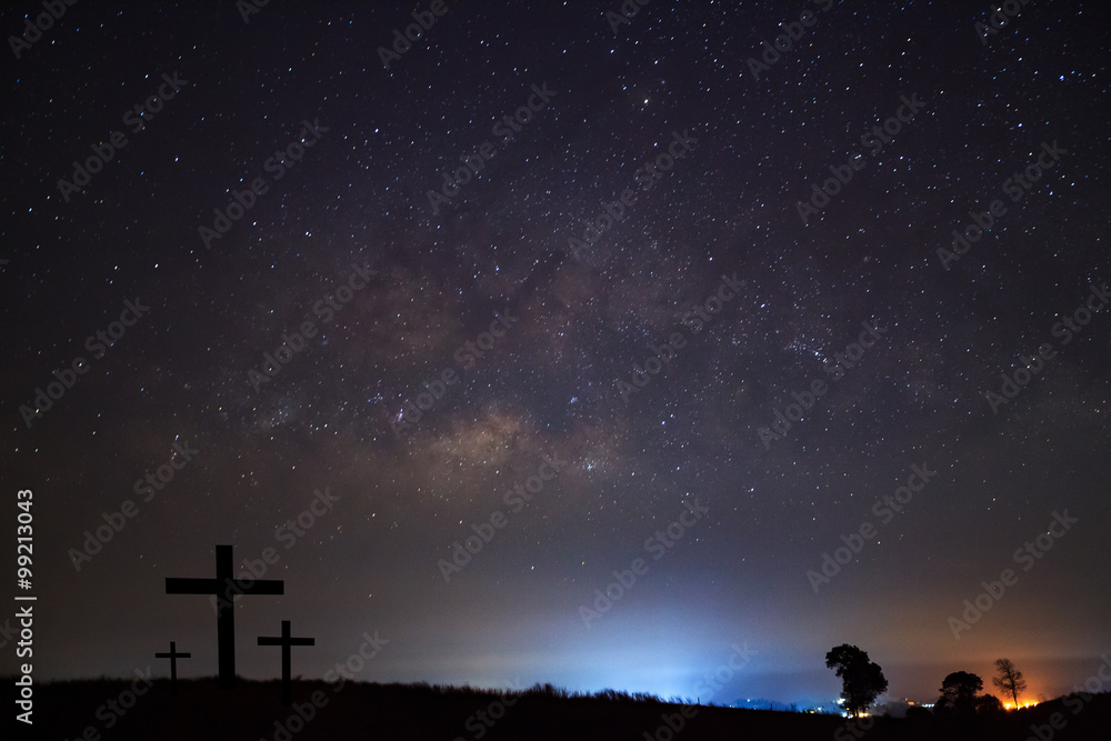 Silhouette of cross over milky way