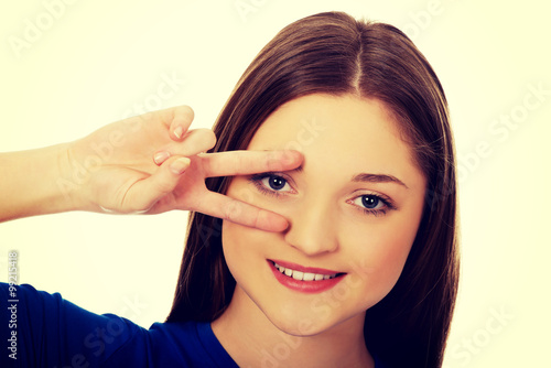 Happy teenager with victory sign on eye.