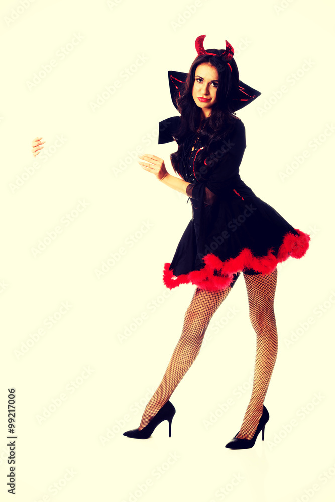 Woman wearing devil clothes holding white banner Woman wearing devil clothes holding white banner