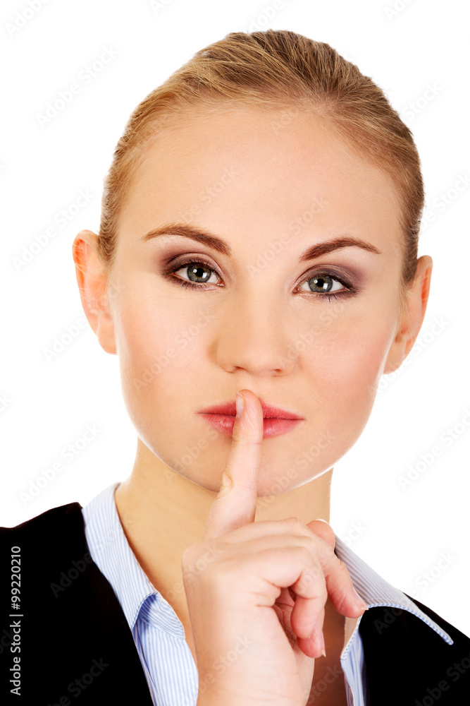Business woman making silent sign with finger on lips Business woman making silent sign with finger on lips