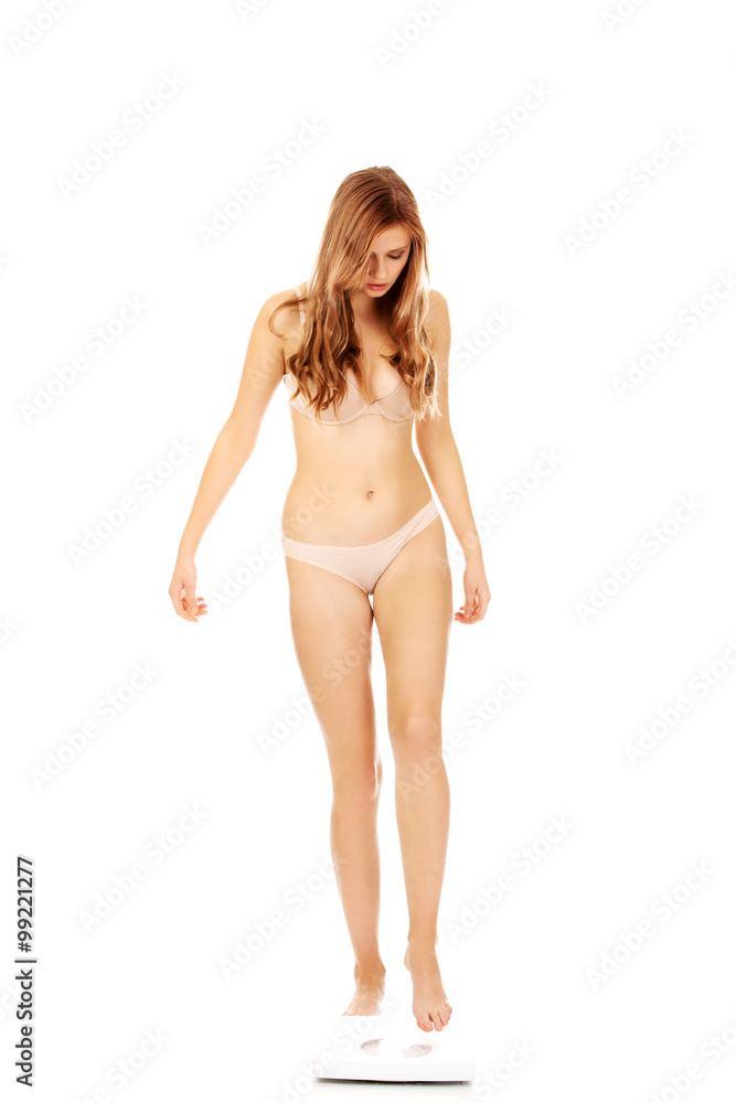 Young woman in underwear standing on scales Young woman in underwear standing on scales
