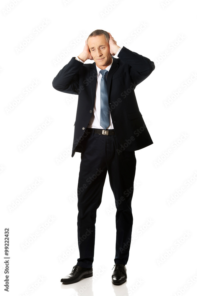 Full length tired man covering ears with hands Full length tired man covering ears with hands