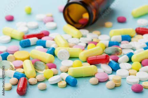 Fotografie Colorful drug pills on blue background, pharmaceutical concept