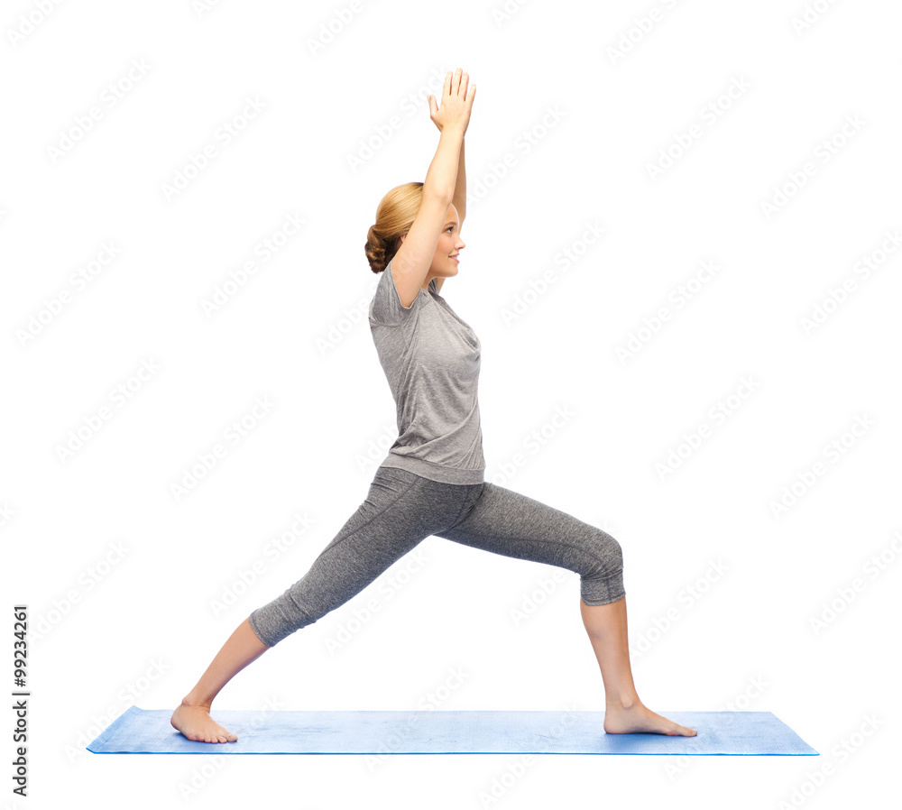 woman making yoga warrior pose on mat woman making yoga warrior pose on mat