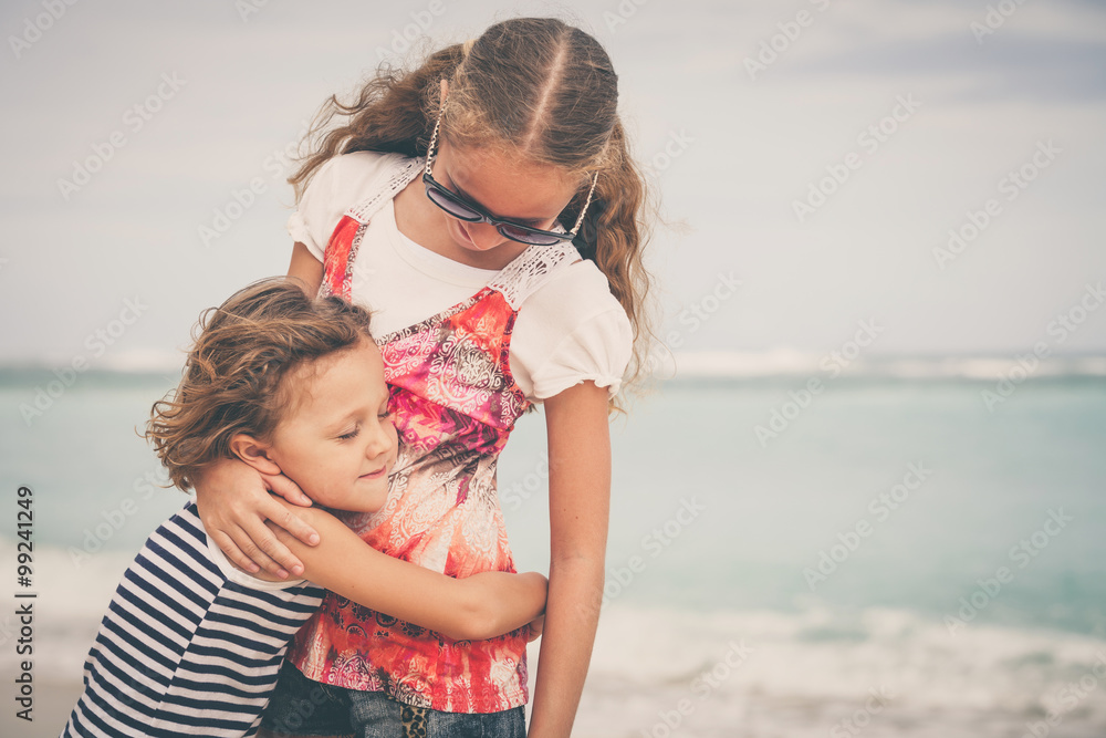 Sister and brother playing on the beach at the day time. Sister and brother playing on the beach at the day time.