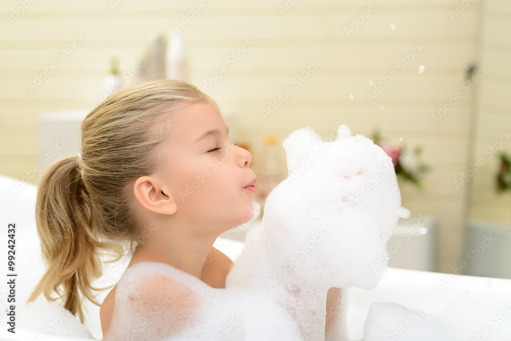 Pleasant little girl playing in bath tube Pleasant little girl playing in bath tube