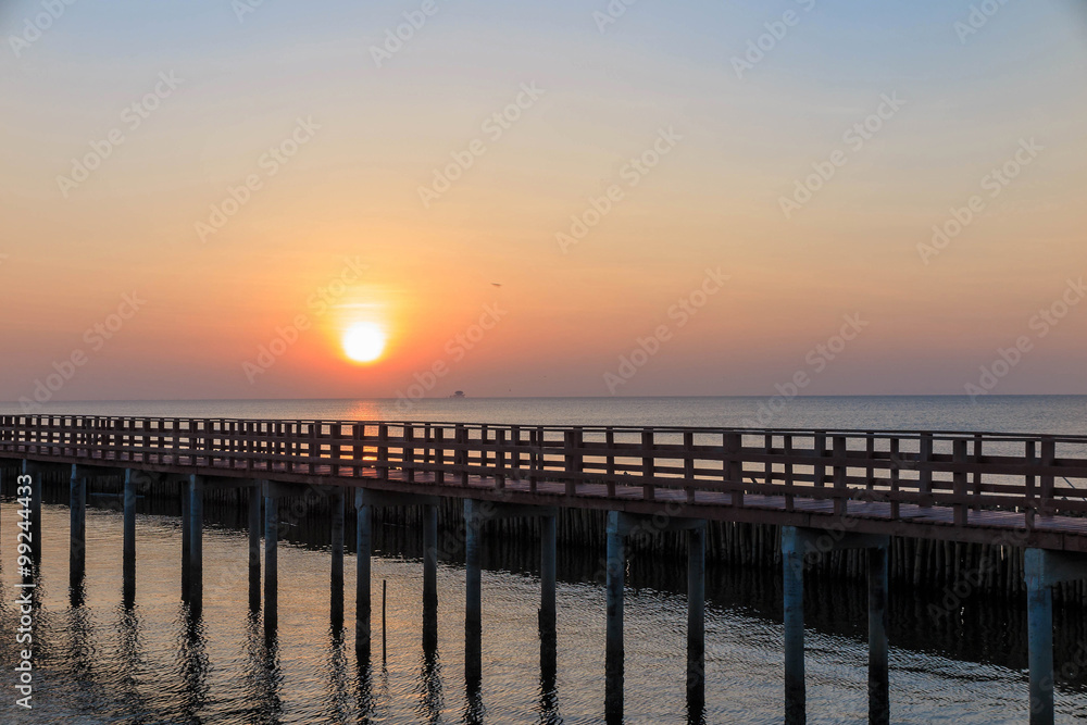 Sunrise in the morning with the wooden bridge view in the sea