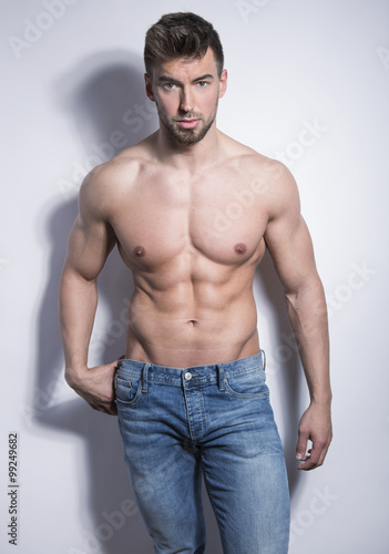 handsome young bodybuilder with toned body posing shirtless