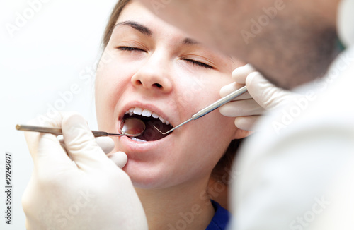 Woman teeth and a dentist mouth mirror. A dentist in a dental cl
