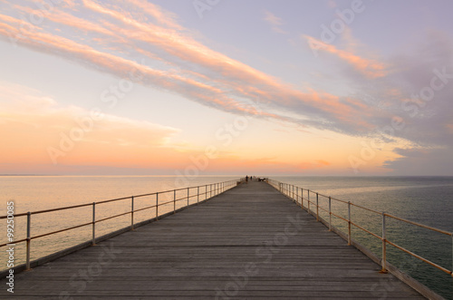 Wooden jetty at dusk with clouds in the sky