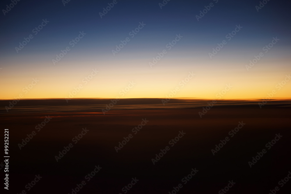 Sonnenuntergang auf Flughöhe / Ein verwischter Sonnenuntergang auf der Flughöhe eines Passagierflugzeugs