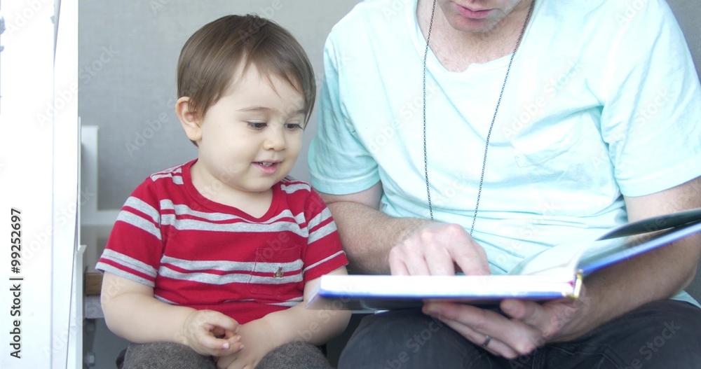 Mixed race family reading book together moving shot Mixed race family reading book together moving shot