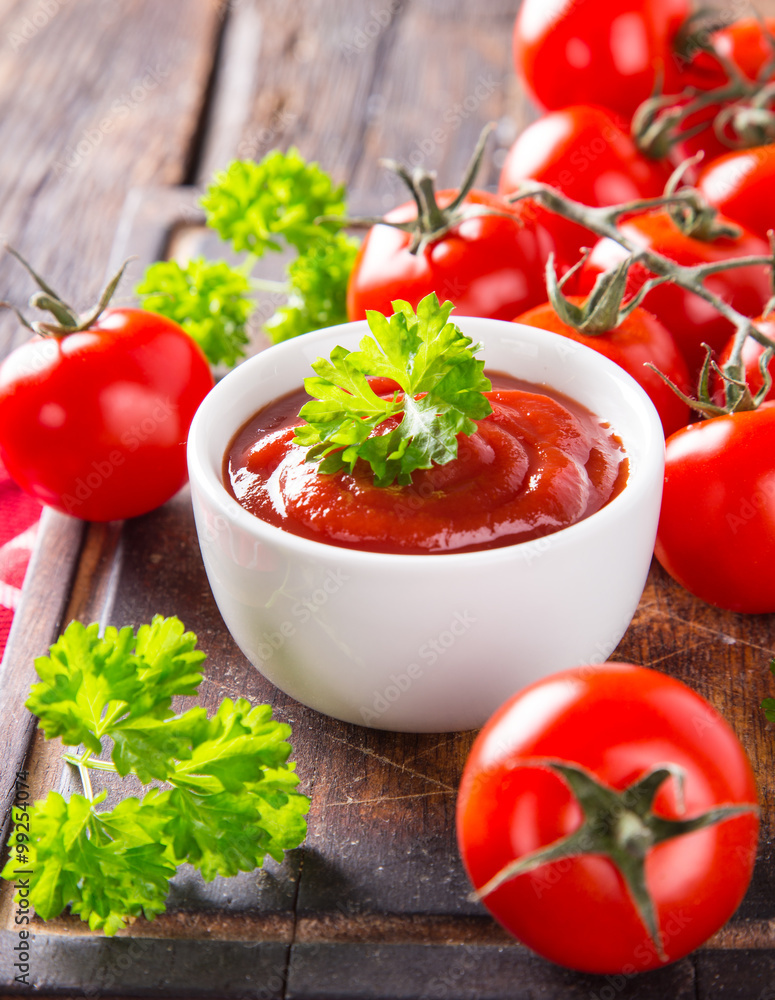 Bowl of tomato sauce and cherry tomatoes on wooden table. Bowl of tomato sauce and cherry tomatoes on wooden table.