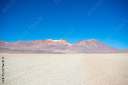 Sandy desert stretch and volcano on the Bolivian Andes