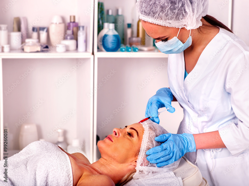 Woman middle-aged in spa salon with beautician. Female giving botox injections. Woman middle-aged in spa salon with beautician. Female giving botox injections.