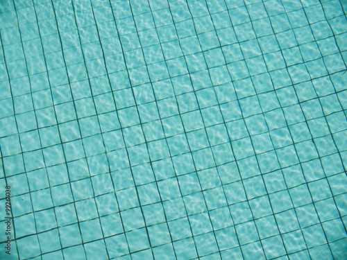 light reflection on water surface of swimming pool with turquoise color tiles on the bottom