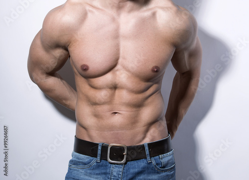 handsome young bodybuilder with toned body posing shirtless