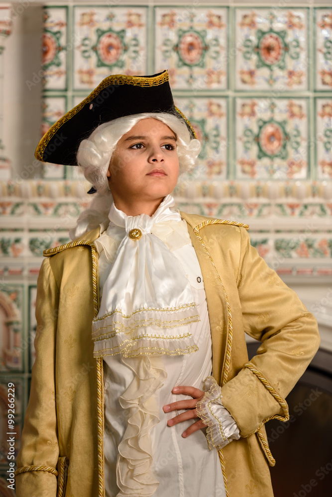 Obraz premium Boy in vintage costume near the fireplace