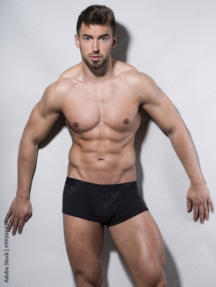 Fototapeta premium handsome young bodybuilder with toned body posing shirtless