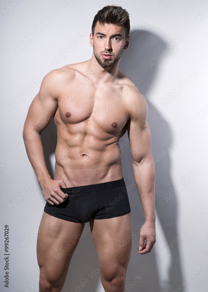 handsome young bodybuilder with toned body posing shirtless