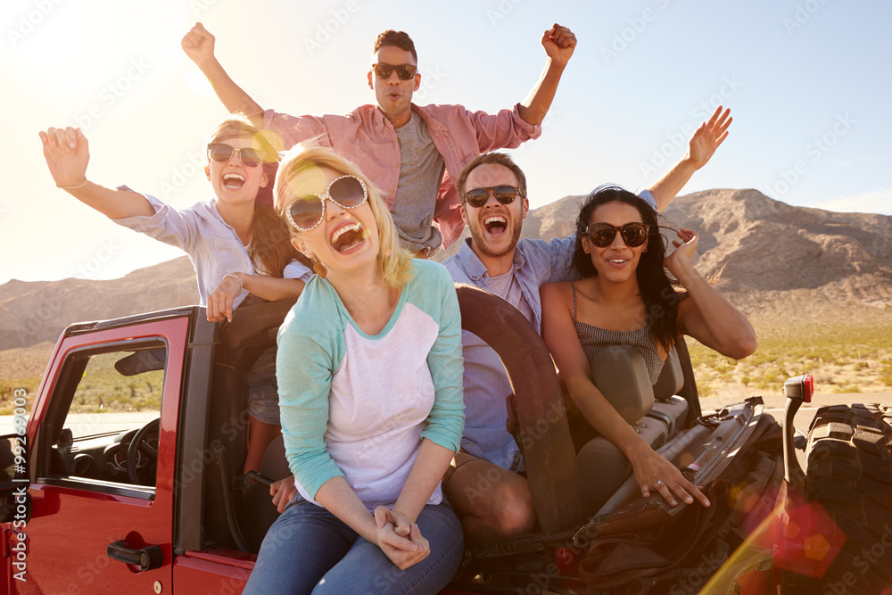 Friends On Road Trip Standing In Convertible Car Friends On Road Trip Standing In Convertible Car