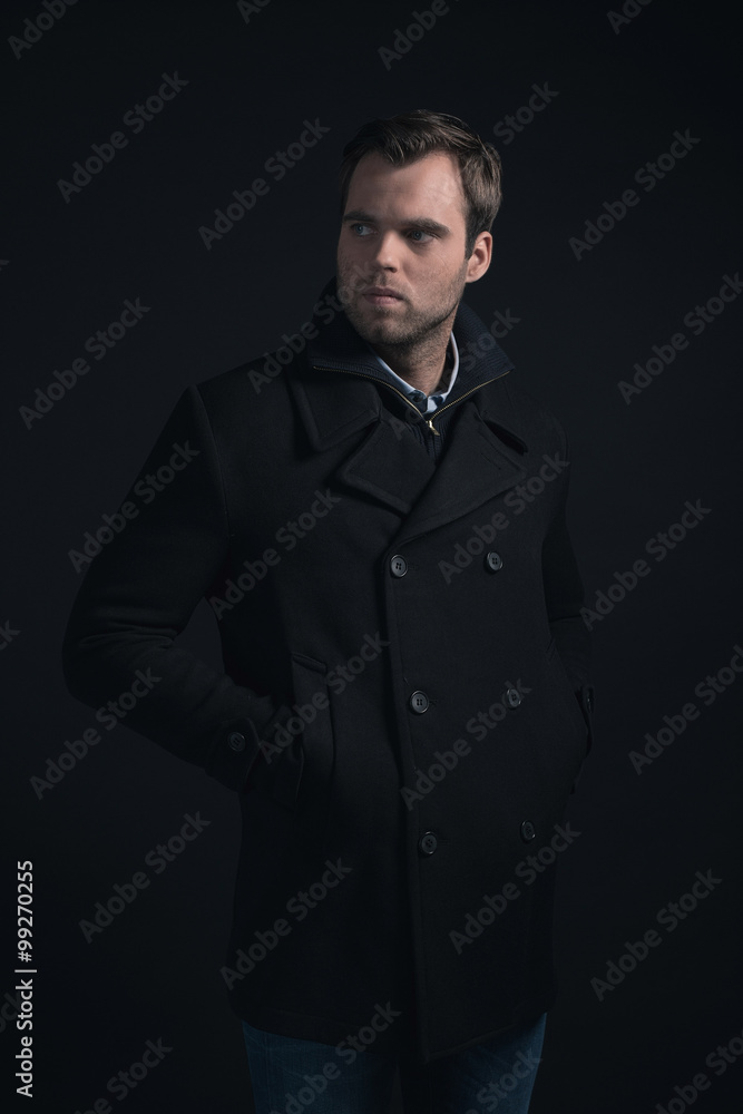 Obraz premium Stubbly bearded young man wearing dark blue winter coat.