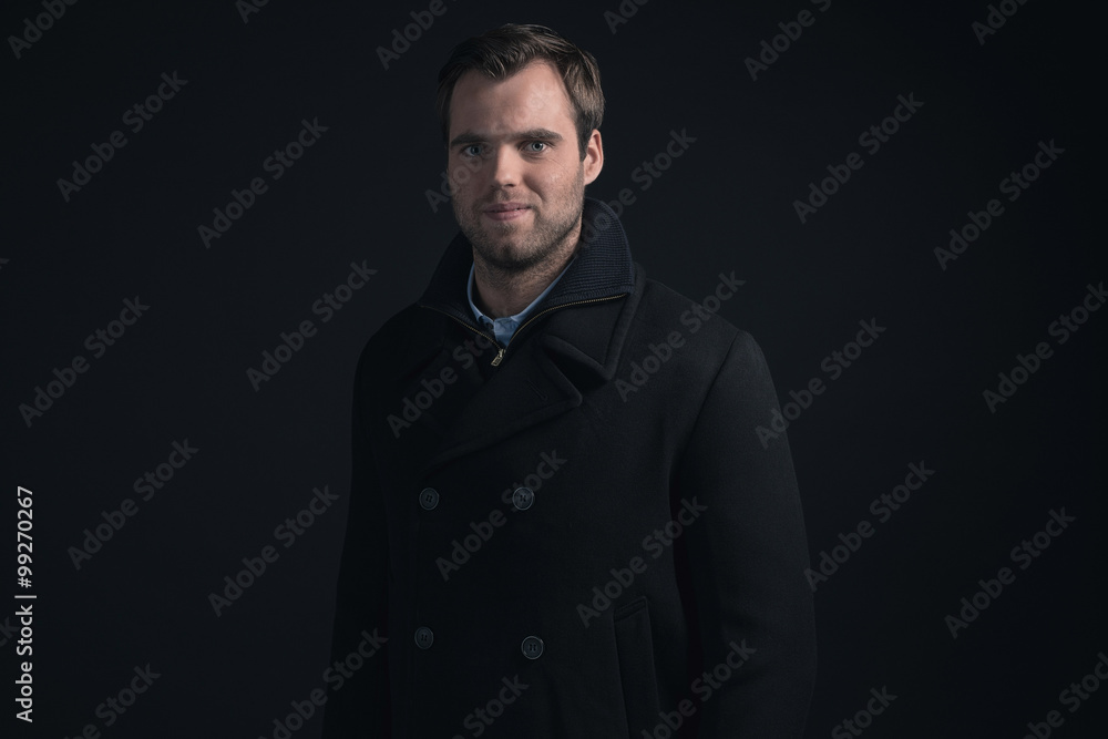 Fototapeta premium Stubbly bearded young man wearing dark blue winter coat.