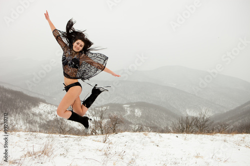 The dark-haired girl in a bathing suit in the winter jump mounta