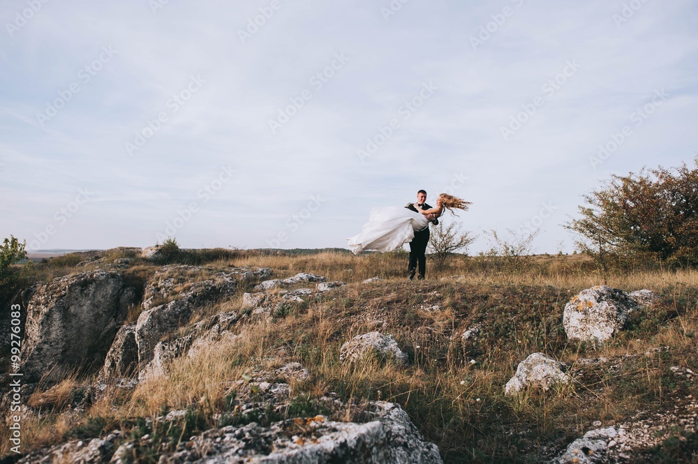 Young newly married couple chasing each other in field Young newly married couple chasing each other in field