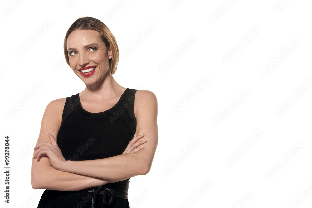 Young woman with arms crossed wearing an elegant black sleeveless dress - isolated Young woman with arms crossed wearing an elegant black sleeveless dress - isolated