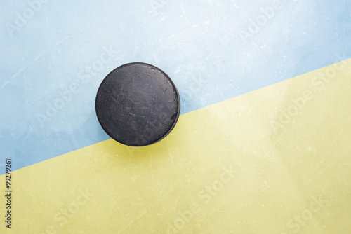 old hockey puck is on the ice with ukraine flag