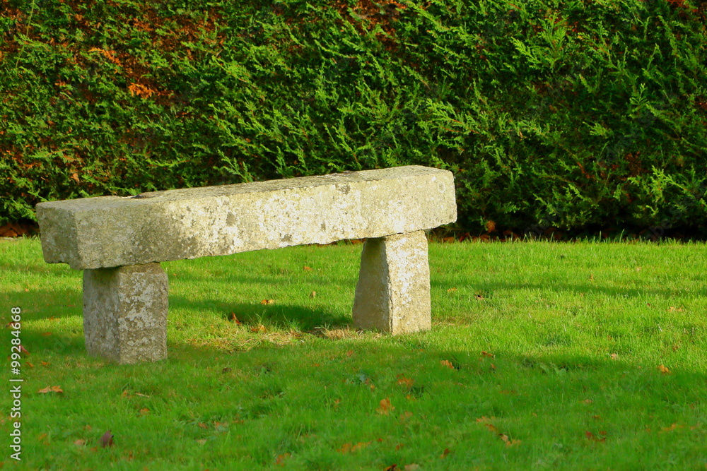 Banc en pierre de granit dans un jardin Photos | Adobe Stock