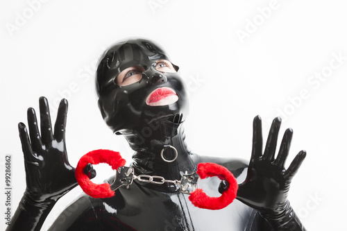 portrait of woman wearing latex clothes with handcuffs photo