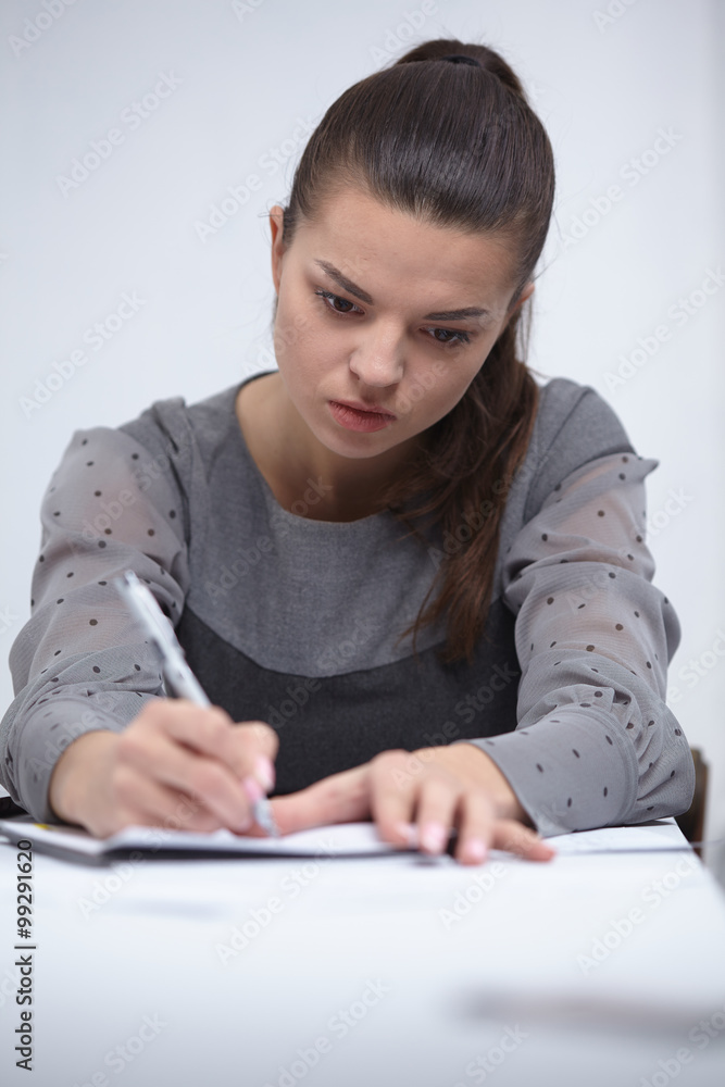 business woman writing in a notepad in the office business woman writing in a notepad in the office