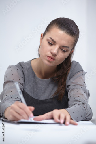 business woman writing in a notepad in the office