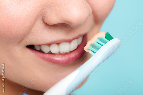 woman holds toothbrush with toothpaste cleaning teeth