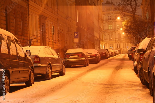 Winter city center street at night with parked cars