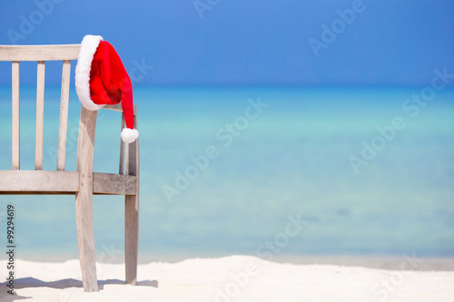 Christmas concept. Red santa hat at tropical white beach.