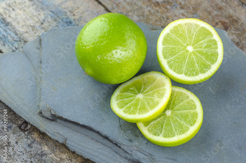 Tahitian limes on a stone background. photo