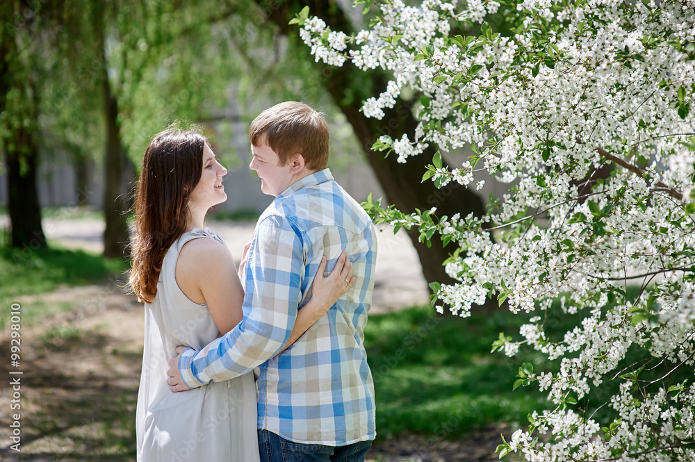 Fototapeta premium young couple in love walking in the blossom spring garden
