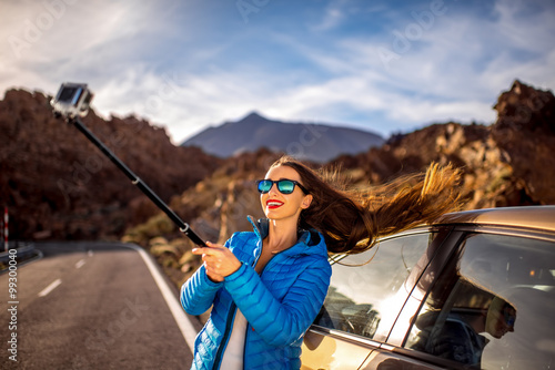 Woman making selfie portrait near the car 