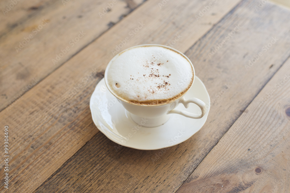 Obraz premium Hot cappuccino on wood background