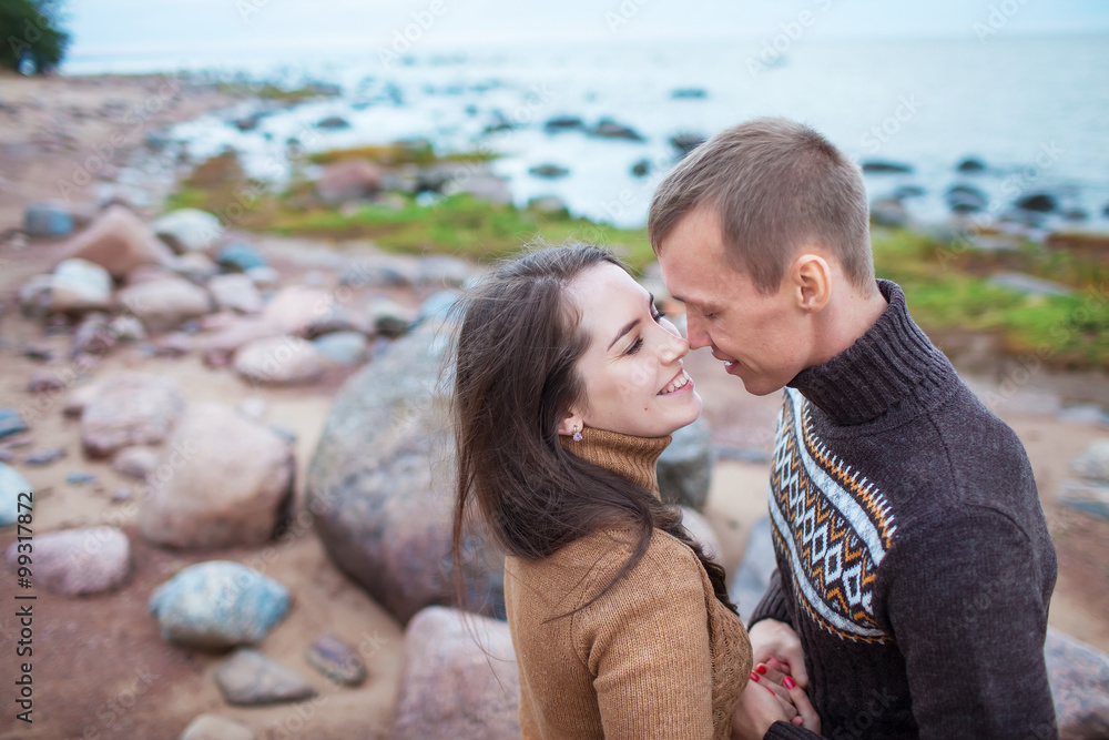 young couple sitting on a rock on the beach young couple sitting on a rock on the beach