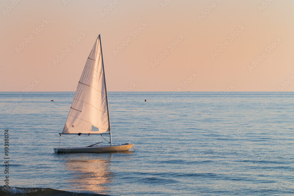 small sailboat in the water next to the beach