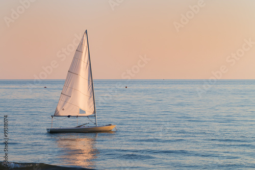 small sailboat in the water next to the beach