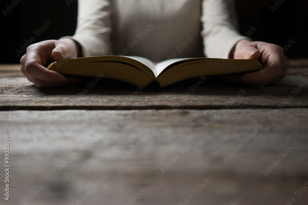 woman hands on bible. she is reading and praying over bible in a woman hands on bible. she is reading and praying over bible in a