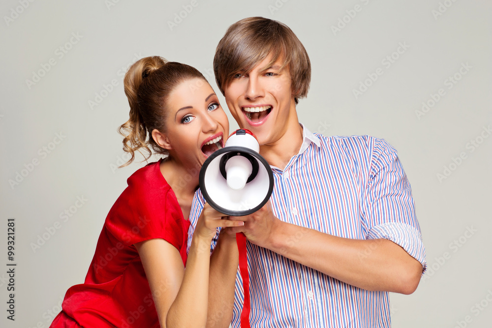 Fototapeta premium Happy couple screaming in megaphone