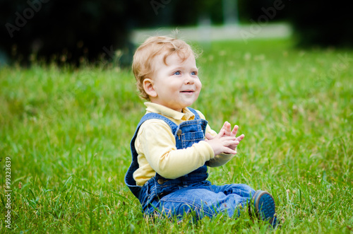 Child on the green lawn in the park