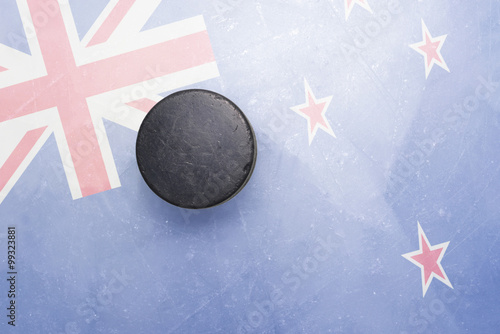 old hockey puck is on the ice with new zealand flag photo