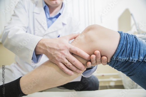 доктор травматолог осматривает ногу и колено пациента крупным планом